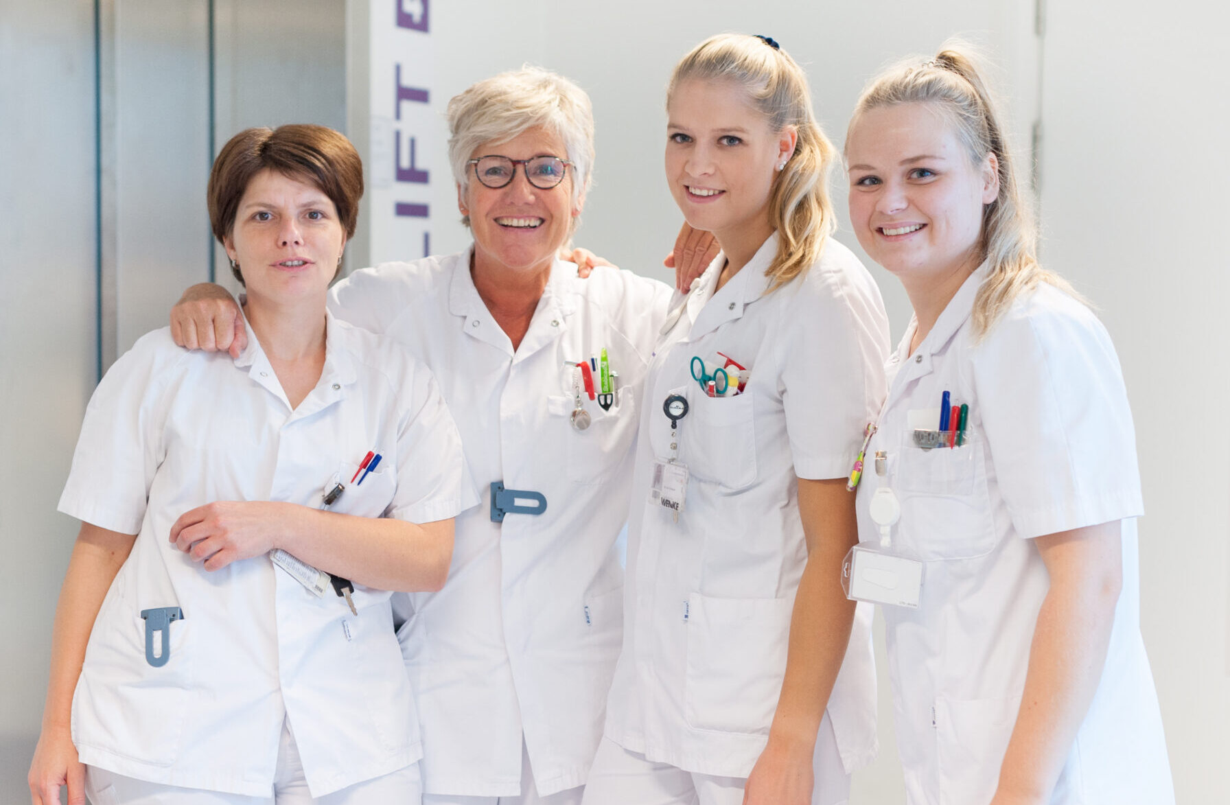 Verpleegkundigen van verschillende generaties poseren samen generaties in het team