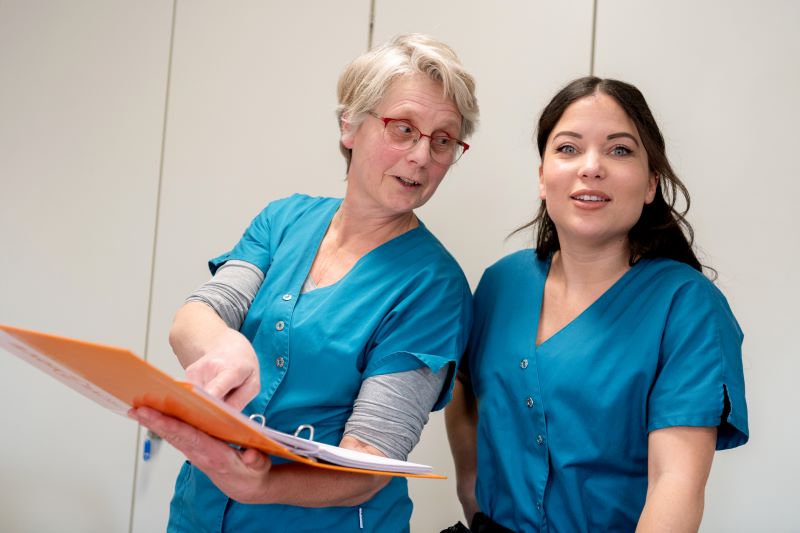 Twee wijkverpleegkundigen nemen samen de cao vvt door.